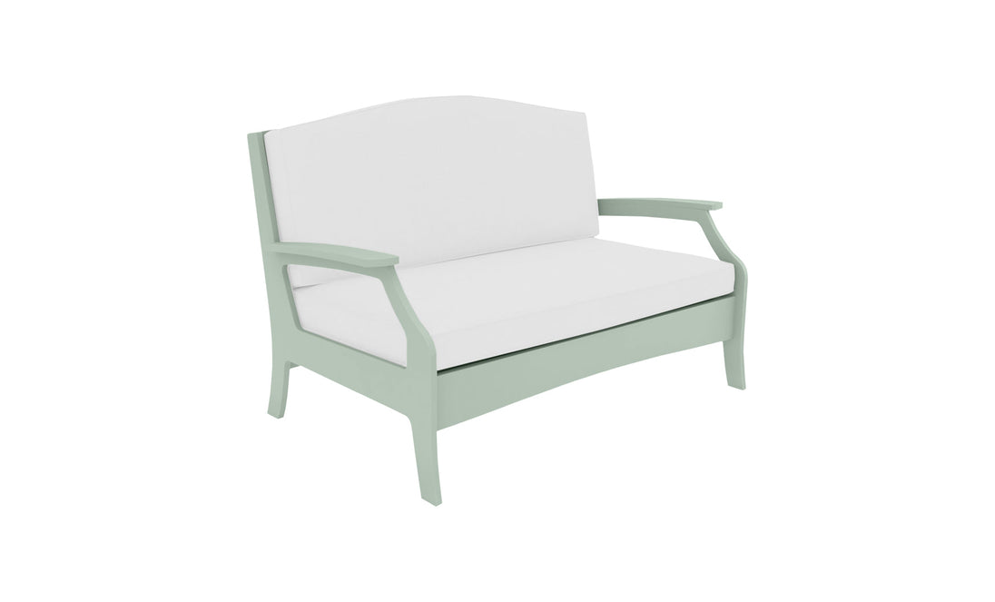 The Ledge Lounger Legacy Loveseat, a light green wooden bench with white cushioned seat and backrest, features curved armrests and a simple yet elegant design. Perfect for any outdoor space, its charm stands out against the white background.