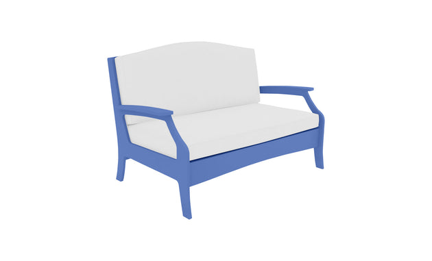The Ledge Lounger Legacy Loveseat features a blue frame and white cushions, offering comfort with an arched backrest and armrests. Its simple, modern design makes it ideal for outdoor spaces.