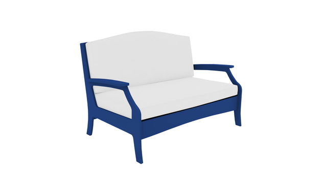 The Ledge Loungers Legacy Loveseat is a blue two-seater with white cushions, featuring cushioned comfort and modern design. Its frame has curved armrests and a high backrest, offering sleek yet comfortable seating for any outdoor space.