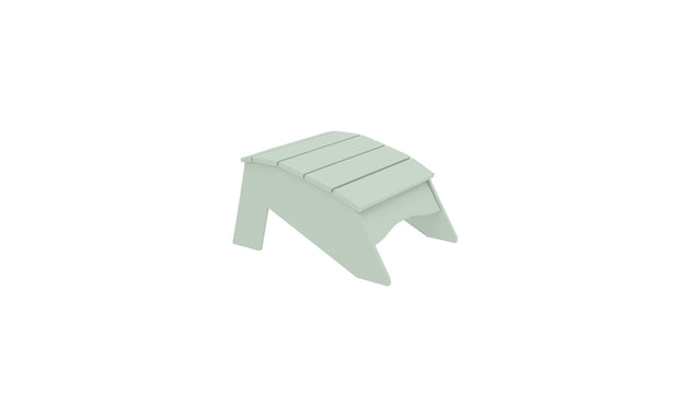 The Ledge Lounger Legacy Adirondack Ottoman is a light green slatted wooden footrest for outdoor relaxation, featuring a slightly curved top and triangular sides, perfect for patios or gardens, isolated on a white background.