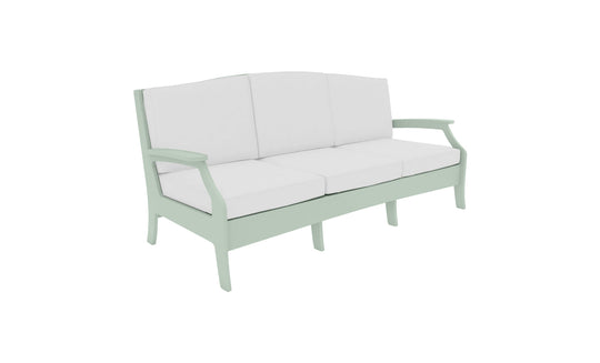 A Legacy Sofa from Ledge Lounger in light green with white cushions is set against a plain white background. The sofa has a modern design with armrests and three cushion sections, made in outdoor fabrics for lasting style and comfort.