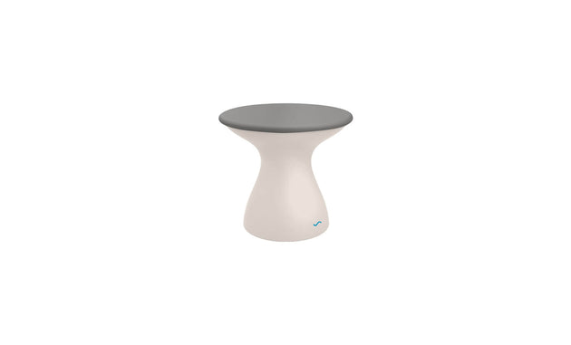 The Autograph Standard Side Table by Ledge Lounger is a small, modern stool with a gray flat top and white hourglass-shaped base, providing a sleek design that also functions as an outdoor side table.