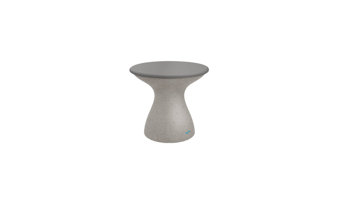 The Autograph Standard Side Table by Ledge Lounger features a small, modern round table with a sleek gray top and a smooth curved pedestal base. Its textured gray base complements the tabletop, making it perfect for stylish poolside storage.