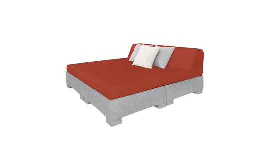The Affinity Square Sunbed with Backrest Cushion by Ledge Lounger features a red mattress, two pillows (white and gray), on a gray elevated block-like platform, ideal for outdoor or poolside relaxation.