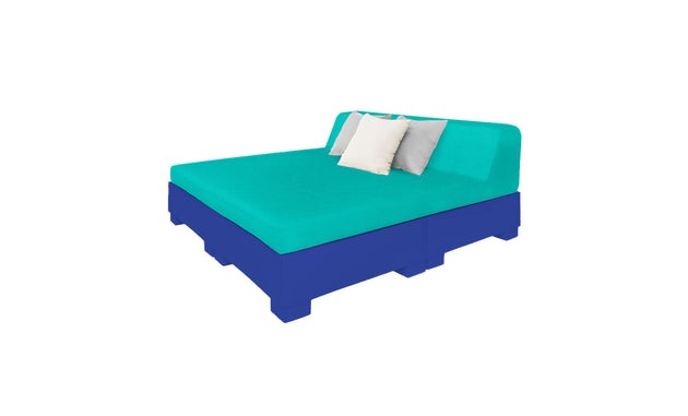 The Affinity Square Sunbed by Ledge Lounger, featuring a teal mattress and backrest on a blue frame, is completed with white and light gray pillows. Its simple geometric design evokes poolside relaxation against a crisp white background.