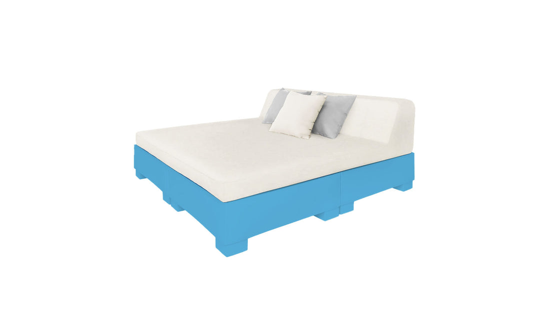 The Affinity Square Sunbed with Backrest Cushion by Ledge Lounger boasts a light cream mattress and headboard on a blue wooden pallet frame, ideal for poolside lounging. It includes decorative white and gray pillows against the headboard, all on a plain white background.