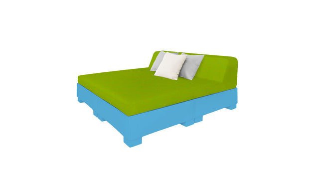 Discover the Affinity Square Sunbed with Backrest Cushion by Ledge Lounger: a modern outdoor sofa featuring a green cushion and two white pillows atop a blue pallet-style base. Its minimalist design and vivid colors create a contemporary look perfect for poolside relaxation.
