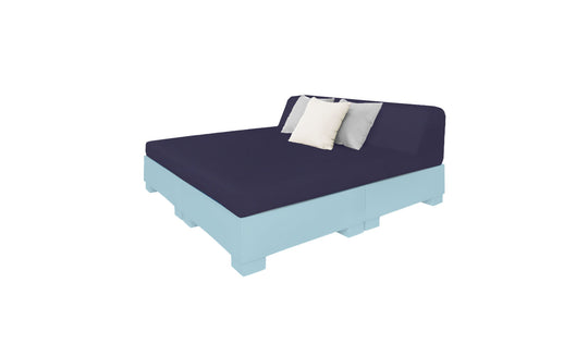 The Affinity Square Sunbed with Backrest Cushion by Ledge Lounger features a dark blue mattress and two pillows, one white and one grey, on a light blue frame and headboard. This setup is perfect for poolside relaxing, bringing indoor cozy comfort to your outdoor space against a white background.