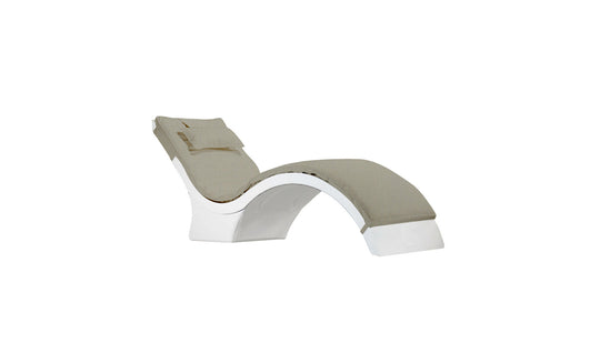 The Ledge Lounger Signature Chaise Cushion features a sleek, curved design with a white base and light beige upholstery, including a matching headrest pillow for added comfort.