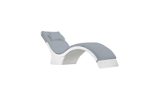 The Signature Chaise Cushion by Ledge Lounger is a modern, curved lounge chair with a gray cushioned seat and backrest, plush headrest pillow, and a sleek white structure for a stylish minimalist design.