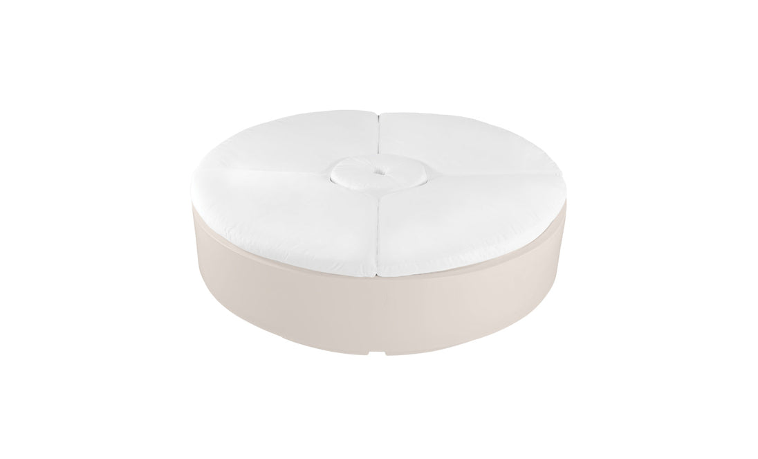 The Signature Round Sunbed by Ledge Lounger features a white cushioned top with a central tufted button detail and a beige base, making it an ideal spot for relaxation in your outdoor space.