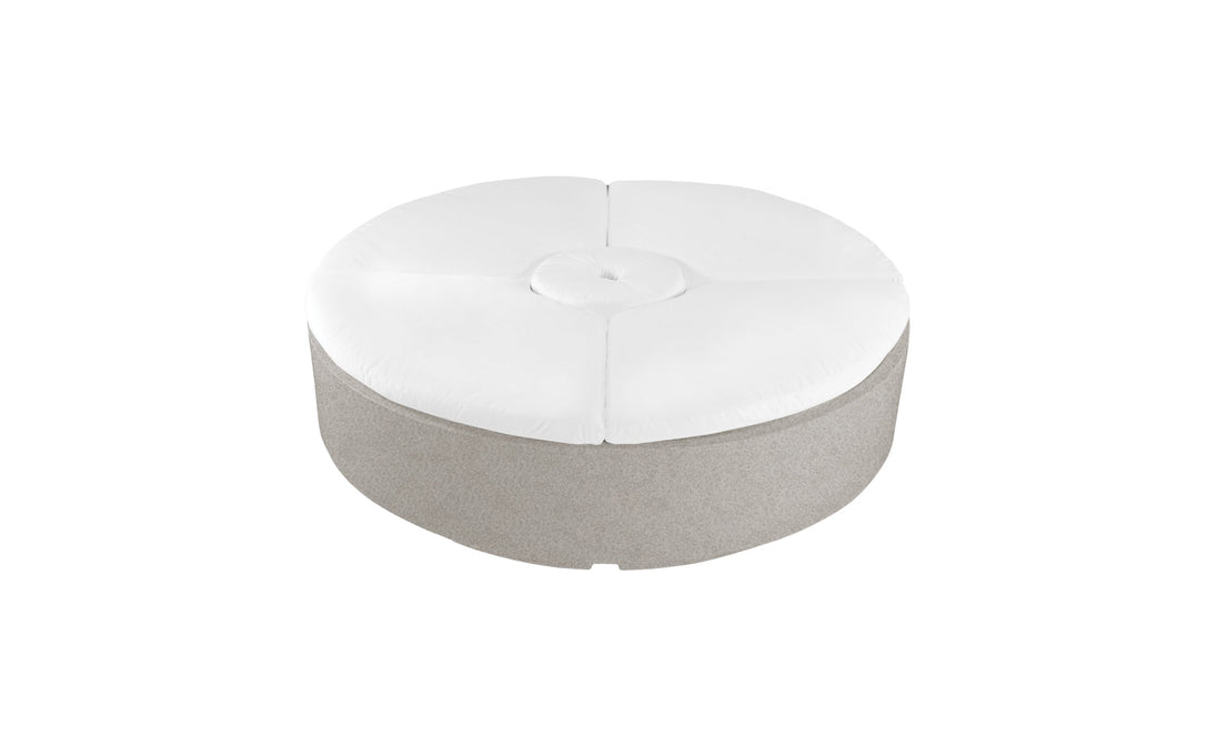 The Signature Round Sunbed by Ledge Lounger features a modern round design with a light gray fabric base and a white cushioned top with central tufted button, perfect for adding style and comfort to any patio or garden.
