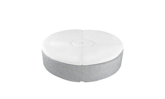 This round, grey ottoman mirrors the Signature Round Sunbed from Ledge Lounger. Ideal for outdoor areas, it features a tufted white cushion with a central button design, offering relaxation on its plain backdrop.