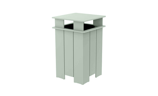 The Ledge Lounger Mainstay Trash Bin is a mint green, square outdoor patio trash can with vertical slats and a flat top. Made from UV stable materials, its open-top design features a covered structure, ideal for public spaces.