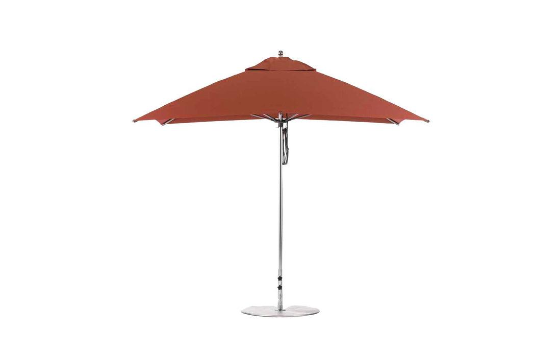 The Essential Fiberglass Umbrella - 10 Square Pulley by Ledge Lounger is shown open and upright against a white background. With its large red canopy, silver metal pole, sturdy base, marine-grade fabrics for durability, and vented top for airflow, its perfect for any patio setting.