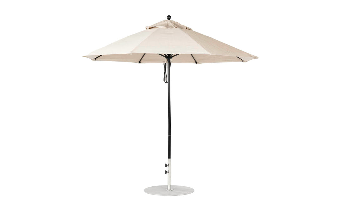 Introducing the Essential Fiberglass Umbrella by Ledge Lounger, featuring a 9 octagon beige canopy from marine-grade fabrics. It includes a central metal pole on a sturdy, flat circular base.