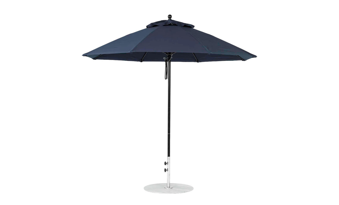 The Ledge Lounger Essential Fiberglass Umbrella features a dark blue octagon canopy, a sleek metal pole, and a round base, all crafted from marine-grade fabrics.