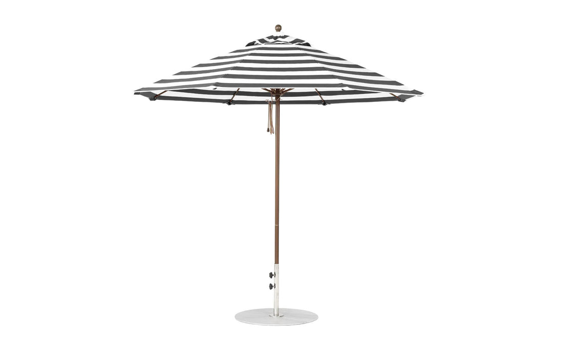A 9 octagon black-and-white striped Essential Fiberglass Umbrella by Ledge Lounger with marine-grade fabric, featuring a wooden pole on a round base. The umbrella is open and shown from the side.