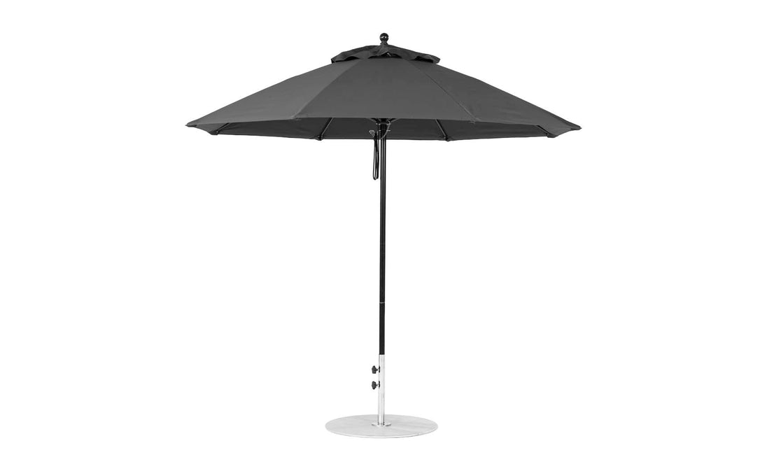 The Ledge Lounger Essential Fiberglass Umbrella - 9 Octagon Pulley, featuring a black canopy on a chrome pole and base, is crafted from marine-grade fabric for durability. Set against a white background, it perfectly combines style and functionality for your patio.