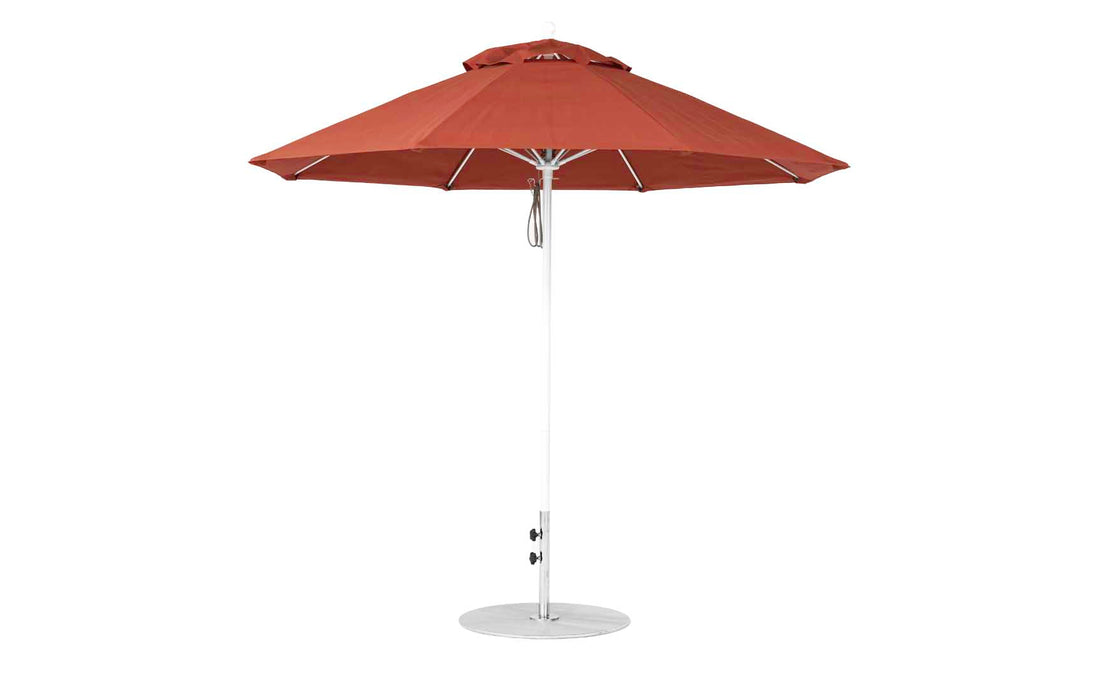 A red 9 octagon Essential Fiberglass Umbrella by Ledge Lounger, featuring marine-grade fabric, a white pole, and a round base, is fully open against a plain white backdrop.