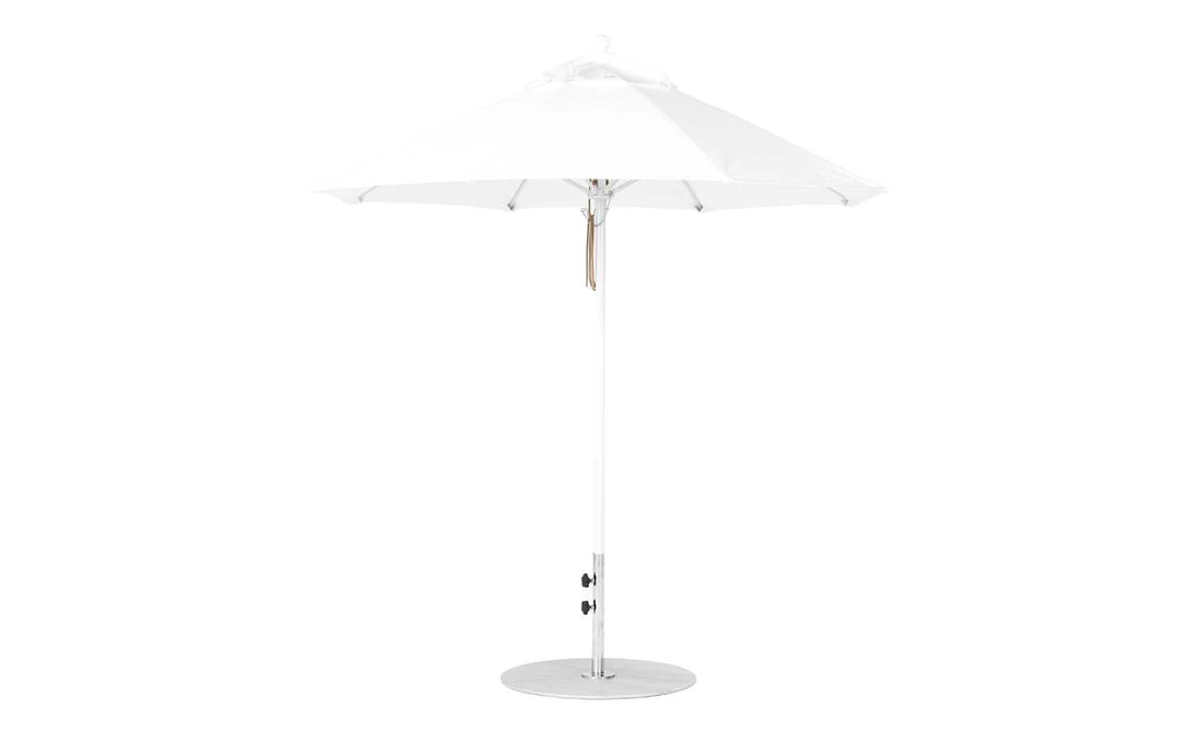 The Essential Fiberglass Umbrella - 7.5 Octagon Pulley by Ledge Lounger is a white, wind-resistant patio umbrella with a modern design featuring a circular base and slender pole, supporting an elegant canopy made from marine-grade fabric. Fully opened, it showcases its symmetrical structure against a plain background.