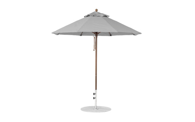 The Ledge Lounger Essential Fiberglass Umbrella features a 7.5 octagonal canopy made from marine-grade fabrics for durability, atop a slender fiberglass pole with a circular base, ideal for garden or patio settings and wind resistance.