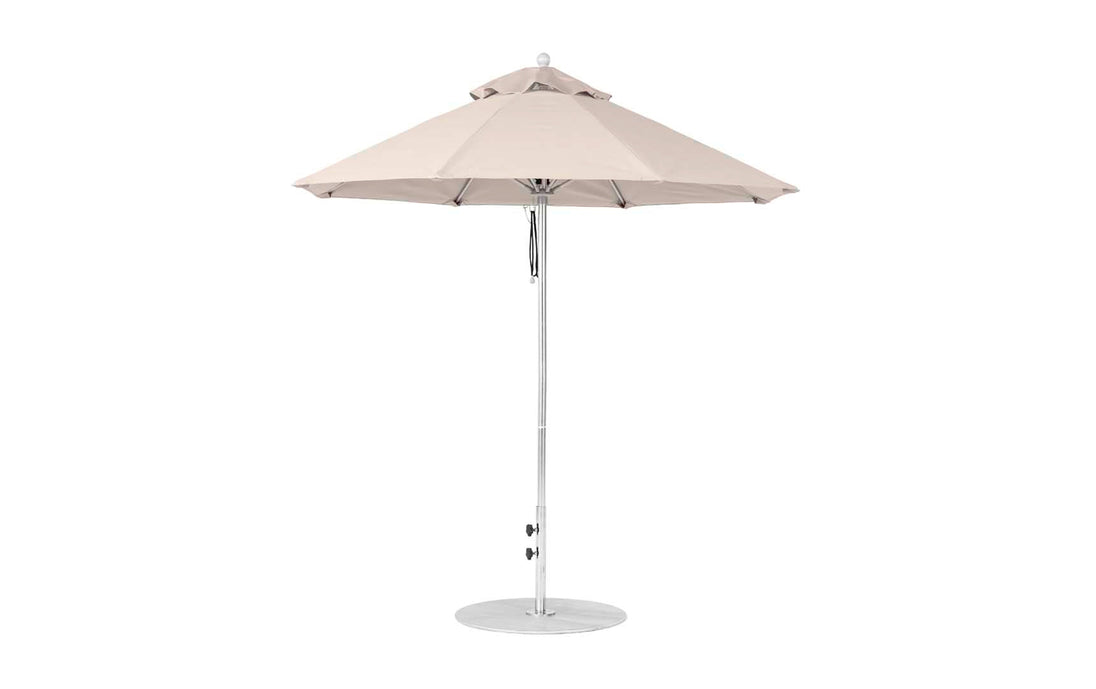 The Ledge Lounger Essential Fiberglass Umbrella features a 7.5 octagon canopy made from durable marine-grade fabrics. With a central metal pole and circular base, this beige patio umbrella offers wind-resistant shade and style for sunny spaces.