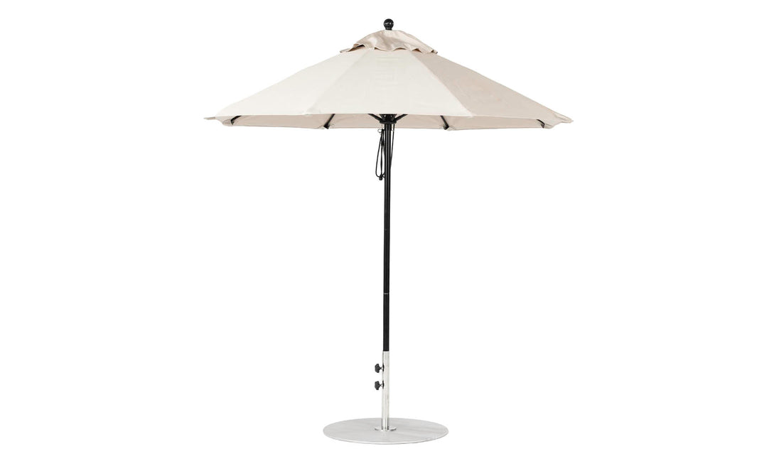 The Ledge Lounger Essential Fiberglass Umbrella - 7.5 Octagon Pulley features a beige marine-grade fabric canopy and black metal pole on a circular silver base, offering wind resistance and an easy pulley system for effortless opening and closing.