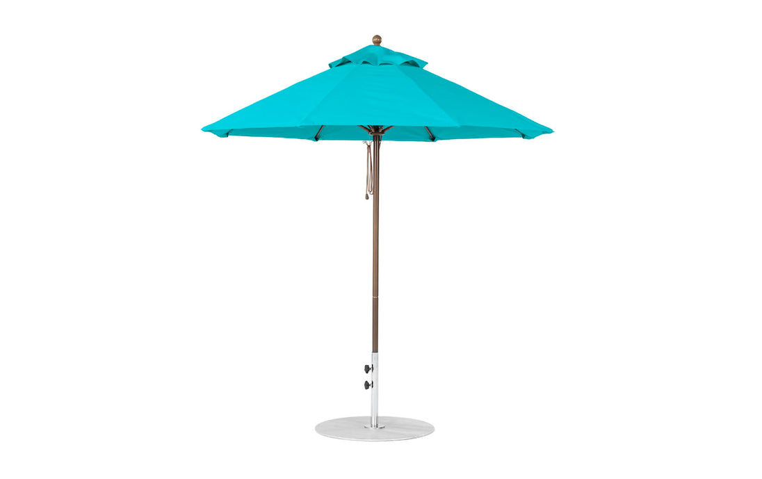 The Ledge Lounger Essential Fiberglass Umbrella - 7.5 Octagon Pulley features a blue canopy with eight marine-grade, wind-resistant sections on a silver pole and round base.