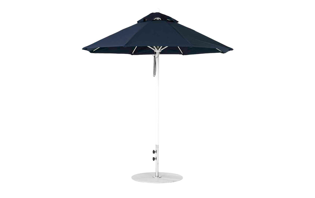 The Ledge Lounger Essential Fiberglass Umbrella - 7.5 Octagon Pulley is a blue patio umbrella with a metal pole and round base, featuring a classic wide canopy from marine-grade fabrics and a vented top for air circulation, enhancing its wind resistance.