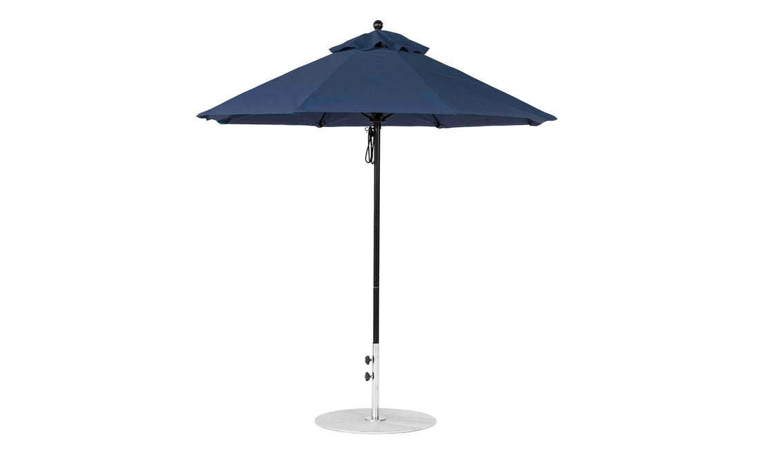 The Essential Fiberglass Umbrella - 7.5 Octagon Pulley by Ledge Lounger features durable navy marine-grade fabric, a straight black pole, and a sturdy circular metal base. This wind-resistant marvel stands proudly against a white background.