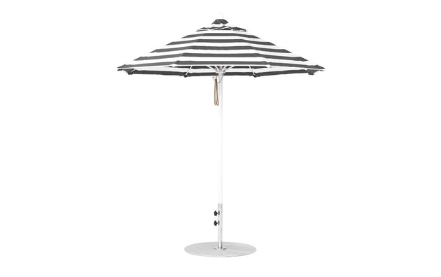 The Ledge Lounger Essential Fiberglass Umbrella features a 7.5 octagon canopy with black and white stripes, a white pole on a round base, crafted from marine-grade fabrics for wind resistance—a classic design ideal for outdoor settings.