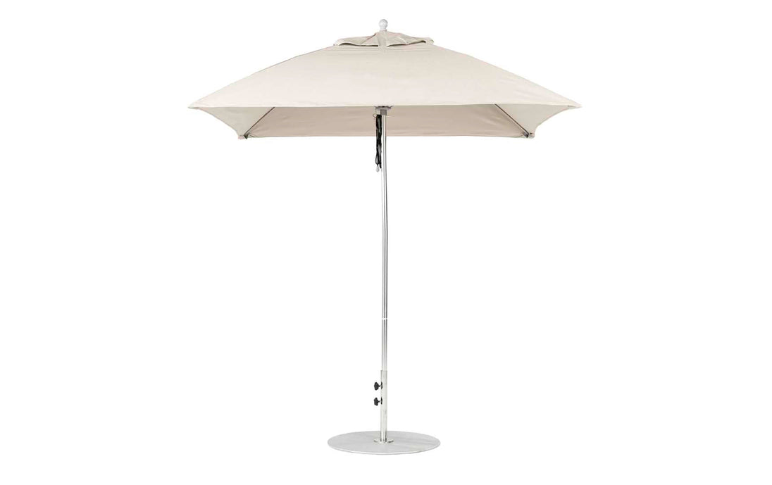 The Ledge Lounger Essential Fiberglass Umbrella, a 7.5 square pulley model in beige, features marine-grade fabrics with a sleek metal pole and round base, standing against a white background. Its modern design enhances any patio setting.