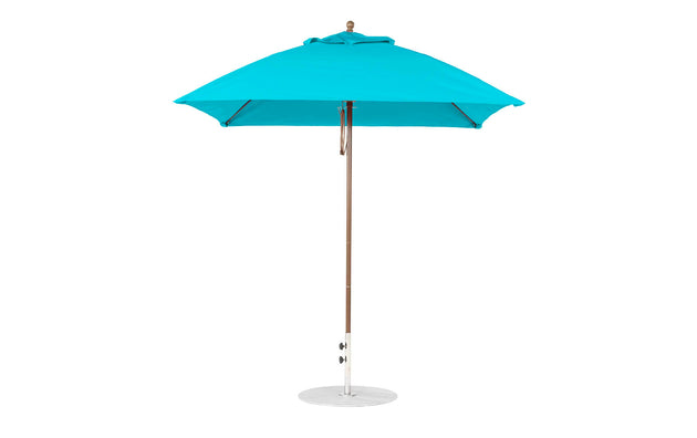 A fully open blue Ledge Lounger Essential Fiberglass Umbrella, with a 7.5 square pulley design, wooden pole, and white metal base, crafted from marine-grade fabrics featuring a classic finial on top, stands against a plain white background.
