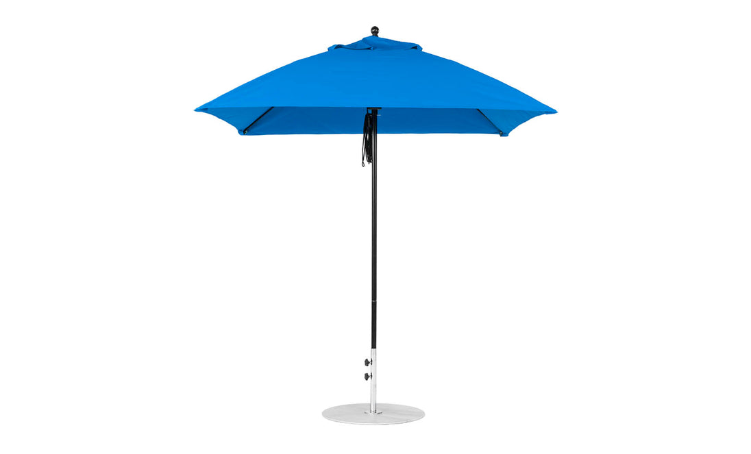 The Essential Fiberglass Umbrella by Ledge Lounger features a 7.5 square design with marine-grade fabric on a pointed top. Its sturdy metal pole rests on a round silver base, combining stylish durability for elegant outdoor shade.