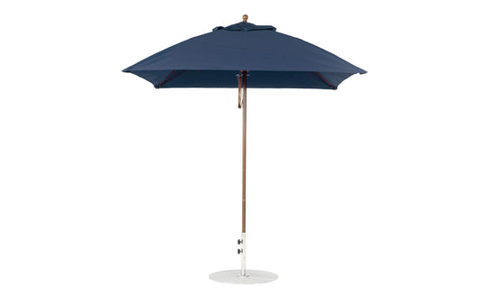 The Ledge Lounger Essential Fiberglass Umbrella features a 7.5 square canopy with marine-grade fabrics for durability, a wooden pole, and a round white base. Its stylish design offers resilience, standing fully open and upright.
