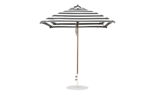 The Ledge Lounger Essential Fiberglass Umbrella in black and white stripes, with marine-grade fabric and a wooden pole, boasts a 7.5 square design with a round white base, showcasing its classic pattern when open.