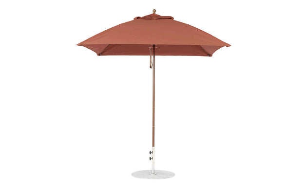 The Ledge Lounger Essential Fiberglass Umbrella, featuring a 7.5 square canopy in red with a straight pole, is open on a round metal base against a plain white background. Made from marine-grade fabrics, it offers durability and style for any garden setting.