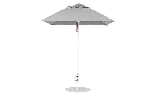 A 6.5 square gray Essential Fiberglass Umbrella by Ledge Lounger has a tall, slim aluminum pole with tilt and height adjustments. Crafted from marine-grade fabrics for durability, it includes a pointed top and a round base for stability.