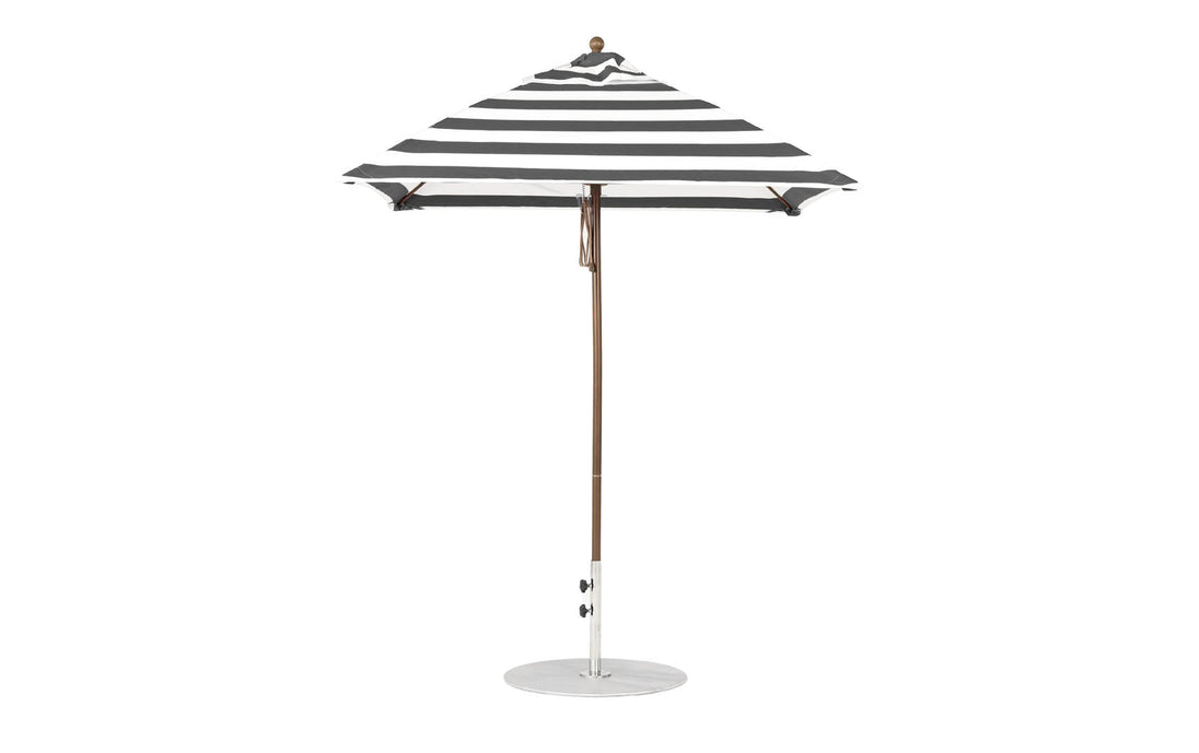 The Ledge Lounger Essential Fiberglass Umbrella - 6.5 Square Pulley has marine-grade fabrics with a black and white striped canopy, a pointed top, and is supported by a slender aluminum pole on a round white base against a plain white background.