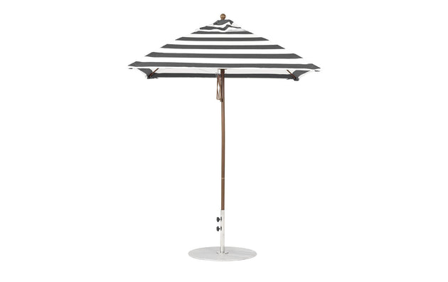 The Ledge Lounger Essential Fiberglass Umbrella - 6.5 Square Pulley has marine-grade fabrics with a black and white striped canopy, a pointed top, and is supported by a slender aluminum pole on a round white base against a plain white background.