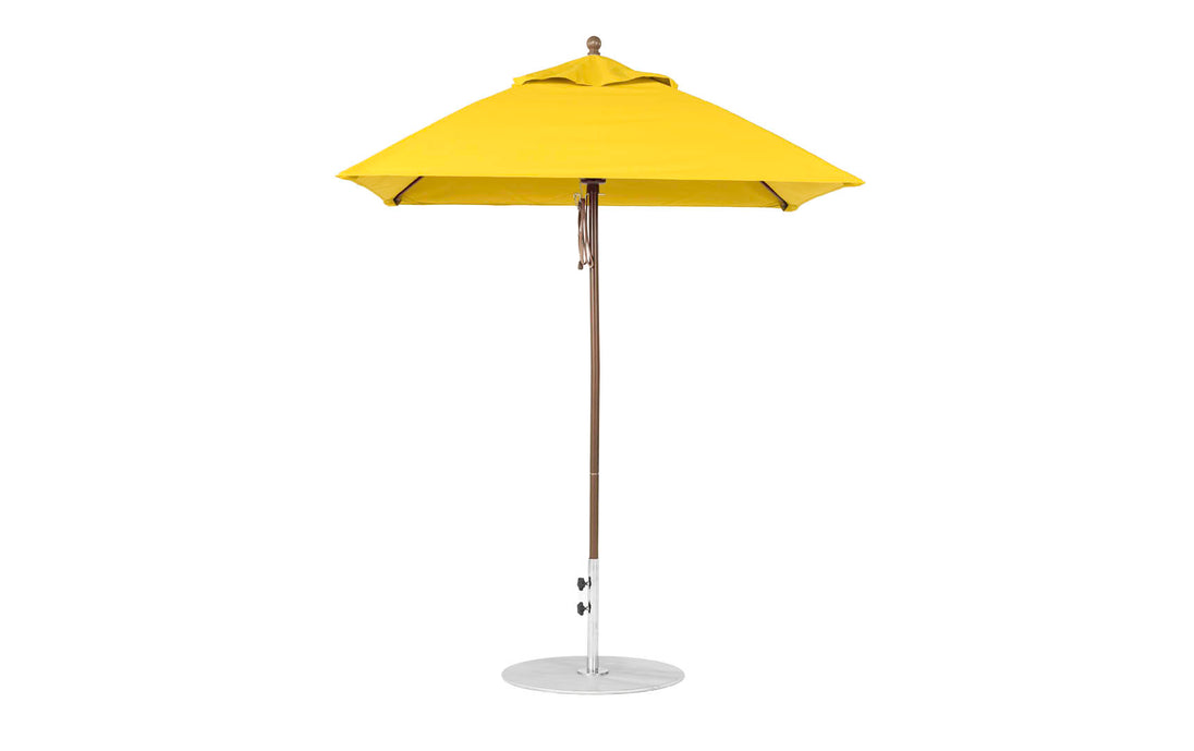 A yellow Essential Fiberglass Umbrella by Ledge Lounger, featuring a 6.5 square canopy and aluminum center pole with round base, stands upright against a white background.