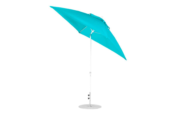 The Essential Fiberglass Umbrella by Ledge Lounger, sized at 7.5, features a turquoise marine-grade fabric and a white pole with a circular base, elegantly tilted against a plain white background.