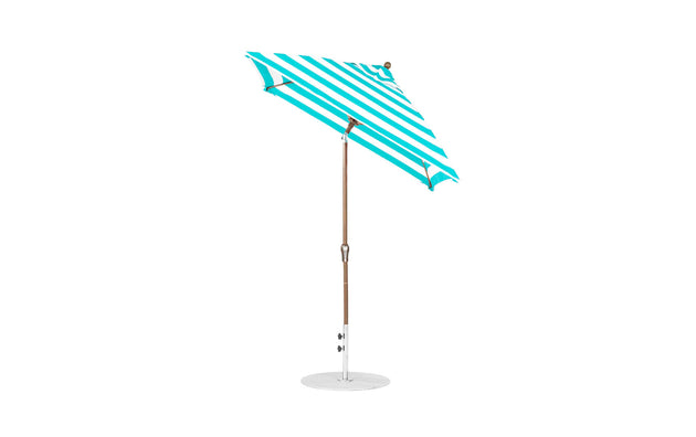 The Essential Fiberglass Umbrella by Ledge Lounger offers a modern, simple design with a turquoise and white striped pattern, wooden pole, and round white base. Its marine-grade fabrics ensure durability, while the 6.5 square shape and auto tilt feature enhance functionality.