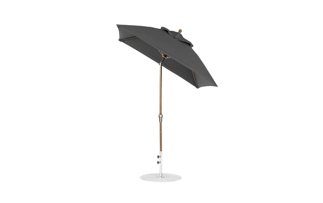 The Ledge Lounger Essential Fiberglass Umbrella is a 6.5 square, black outdoor umbrella with a curved canopy, crafted from marine-grade fabrics, mounted on a white circular base with a sturdy wooden pole and adjustable arm featuring crank auto tilt.
