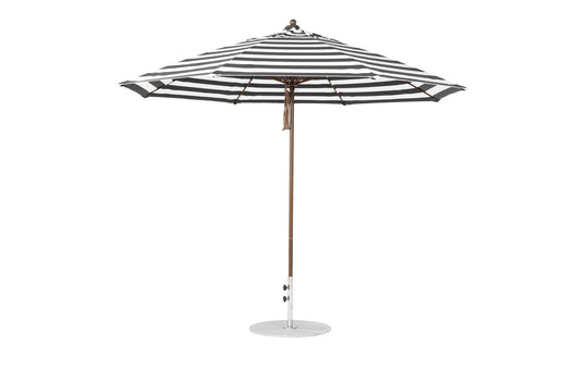 The Essential Fiberglass Umbrella by Ledge Lounger features an 11 octagon canopy in black and white stripes, supported by a wooden pole on a circular metal base. The canopy is fully open, crafted from marine-grade fabrics for enhanced durability.