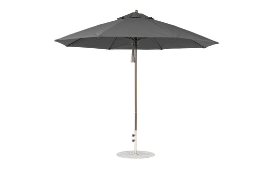 The 11 Octagon Pulley Essential Fiberglass Umbrella by Ledge Lounger stands upright with a wooden pole and metal base. Its sleek, modern design, wind resistance, and marine-grade fabrics make it ideal for any outdoor setting.