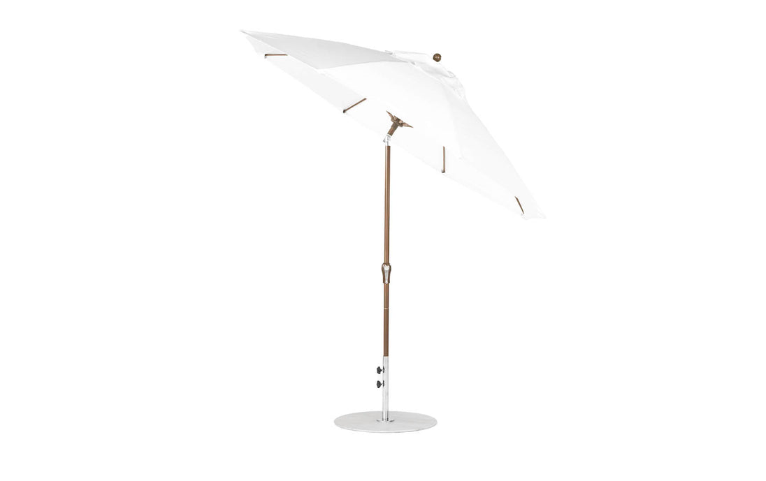 The Ledge Lounger Essential Fiberglass Umbrella features a 9 octagon canopy with crank auto tilt, durable wooden pole, and marine-grade fabrics, offering reliable shade and style for patios or gardens with its sleek design against a plain white backdrop.