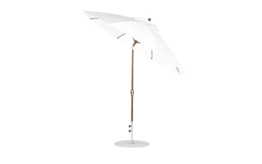 The Ledge Lounger Essential Fiberglass Umbrella features a 9 octagon canopy with crank auto tilt, durable wooden pole, and marine-grade fabrics, offering reliable shade and style for patios or gardens with its sleek design against a plain white backdrop.