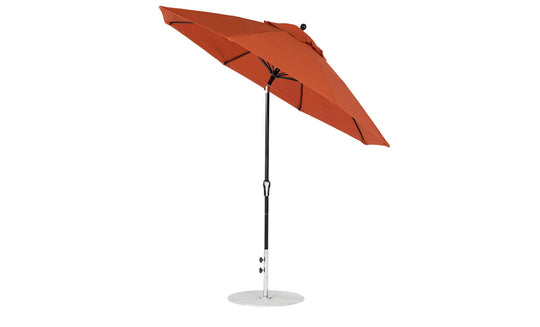 A red 9 Octagon Crank Auto Tilt Essential Fiberglass Umbrella by Ledge Lounger features a black pole, round silver base, and marine-grade fabric. Slightly tilted with taut fabric and defined ribs for durability.